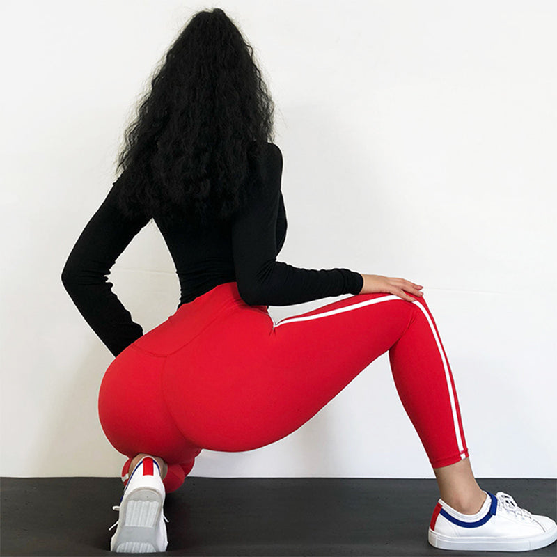 Woman wearing high-waisted yoga pants in blue, showcasing slimming fit and tummy control design